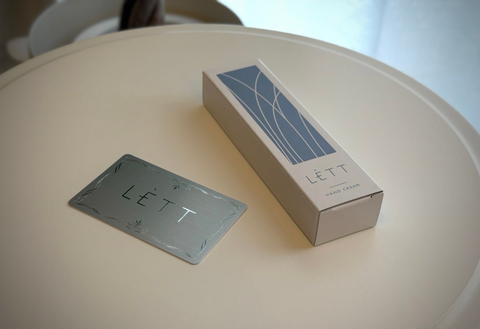 アイボリーのテーブルに置かれたLETTのボックスとオリジナルカード